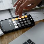 person using calculator payroll employer of record